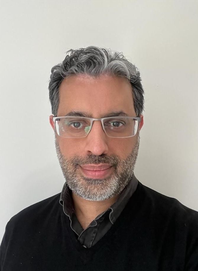 Male GP in glasses and a black top